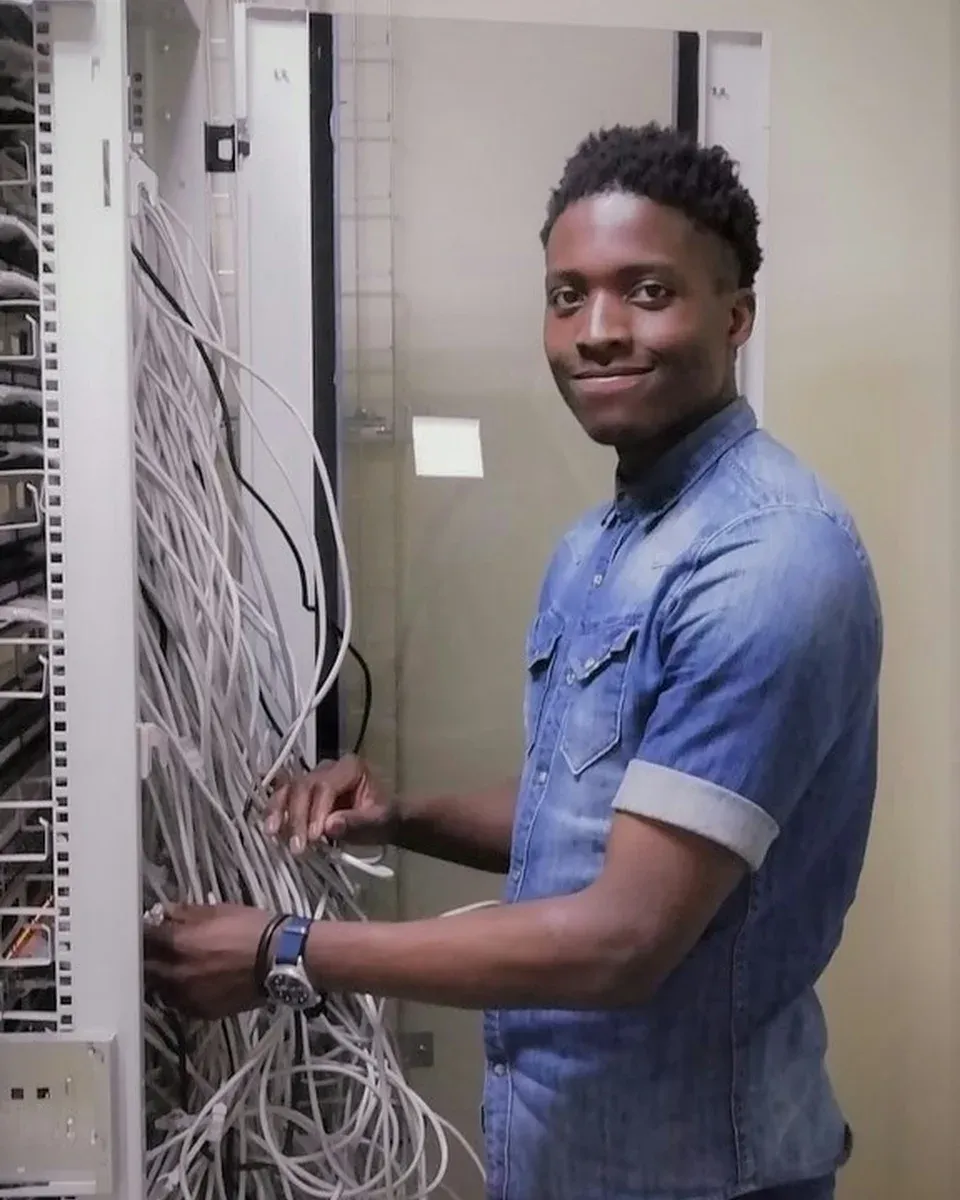 Técnico sonriendo mientras conecta cables en un gabinete
